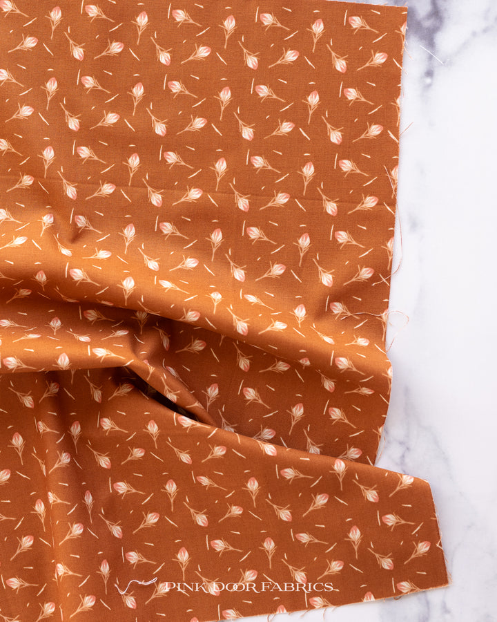 Cotton quilting fabric pattern called 'Thistle in Rust'. Part of the 'Scout Lake' fabric collection. Designed by Ash Cascade for fabric company RJR Fabrics. SKU: AC402-RU4. 44-45 inch width.