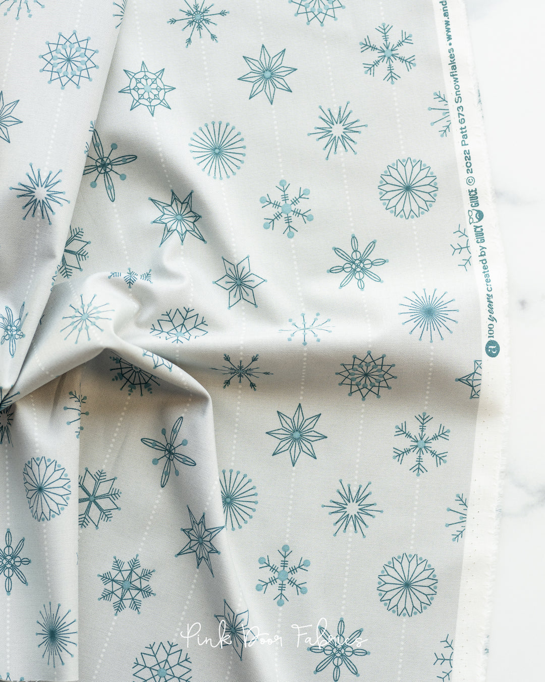 Cotton quilting fabric pattern called 'Snowflakes in Grigio'. Part of the 'Natale' fabric collection. Designed by Giucy Giuce for fabric company Andover Fabrics. SKU: A-673-C. 44-45 inch width.