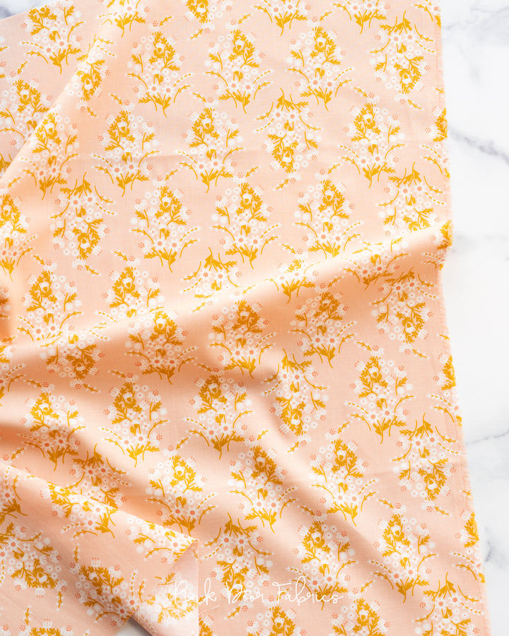 Cotton quilting fabric pattern called 'Wild Flower Child in Peach'. Part of the 'Sunbeam' fabric collection. Designed by Rashida Coleman Hale for fabric company Moda Fabrics. SKU: RS1059 16. 44-45 inch width.