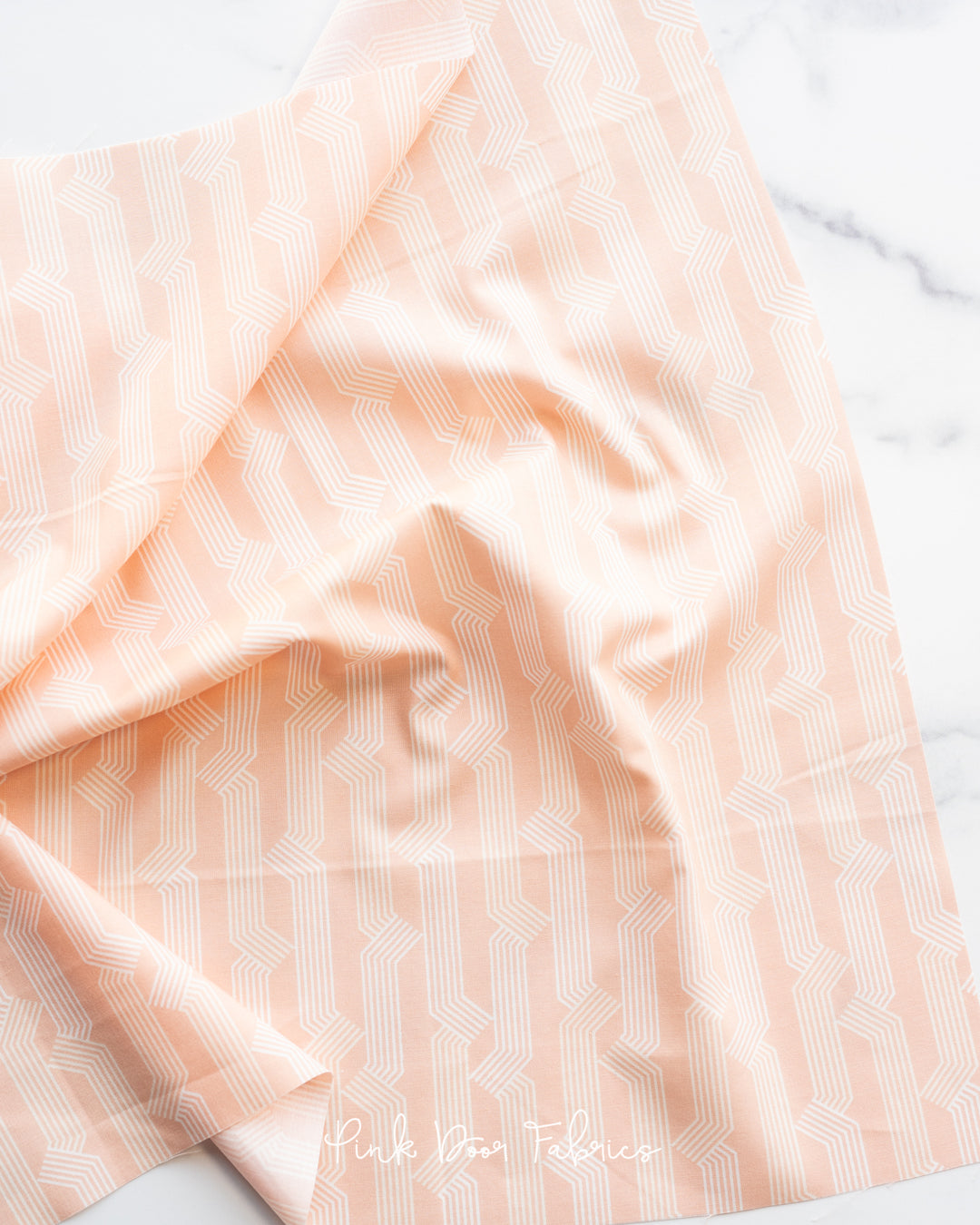 Cotton quilting fabric pattern called 'Folding in Peach'. Part of the 'Sunbeam' fabric collection. Designed by Rashida Coleman Hale for fabric company Moda Fabrics. SKU: RS1061 15. 44-45 inch width.