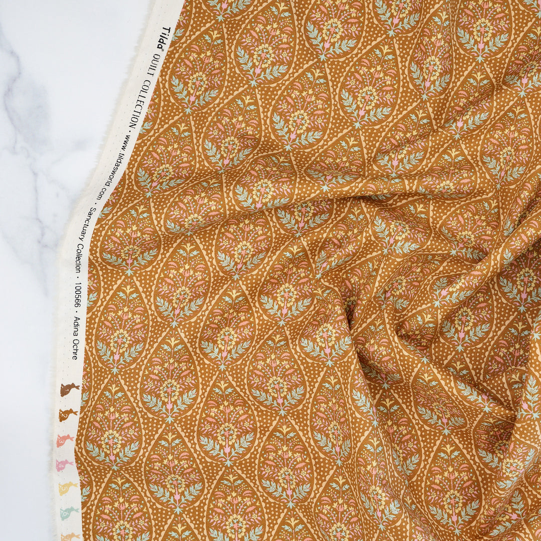 Cotton quilting fabric pattern called 'Adina in Ochre'. Part of the 'Sanctuary' fabric collection. Designed by Tone Finnanger for fabric company Tilda Fabrics. SKU: TIL100566. 44-45 inch width.