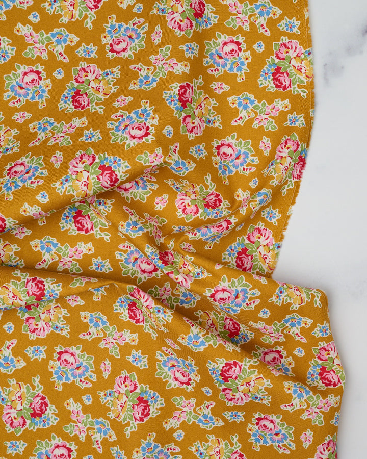 Cotton quilting fabric pattern called 'Sue in Mustard'. Part of the 'Jubilee' fabric collection. Designed by Tilda Fabrics for fabric company Tilda Fabrics. SKU: 100549. 44-45 inch width.