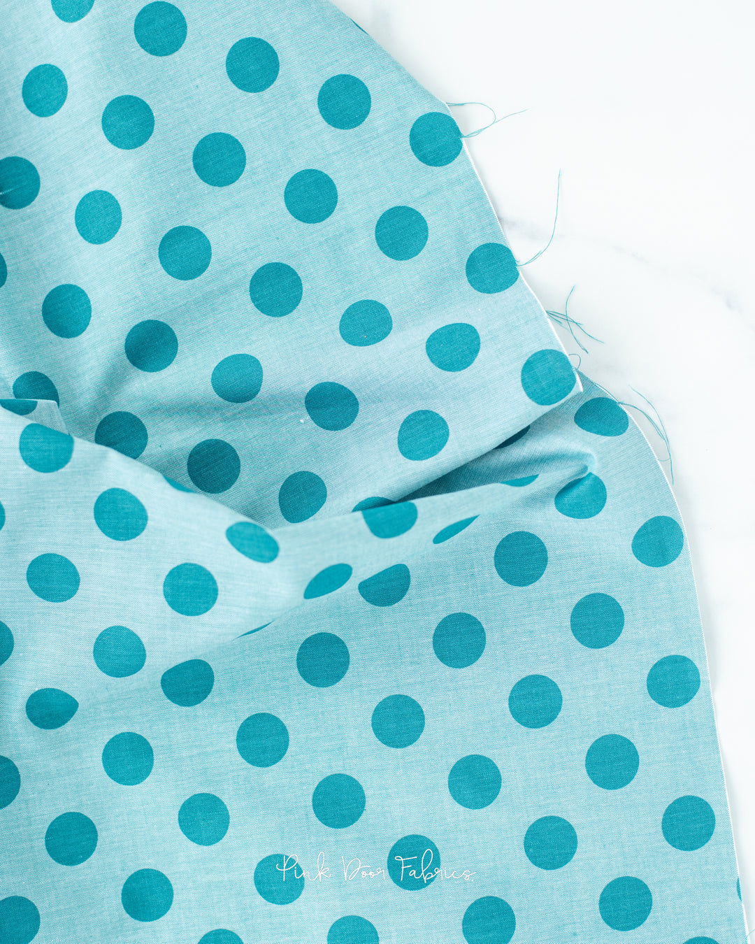 Chambray quilting fabric pattern called 'Aqua'. Part of the 'Chambray Dots' fabric collection. Designed by Tilda Fabrics for the Tilda Fabrics fabric company. SKU: 160058. 44-45 inch width.